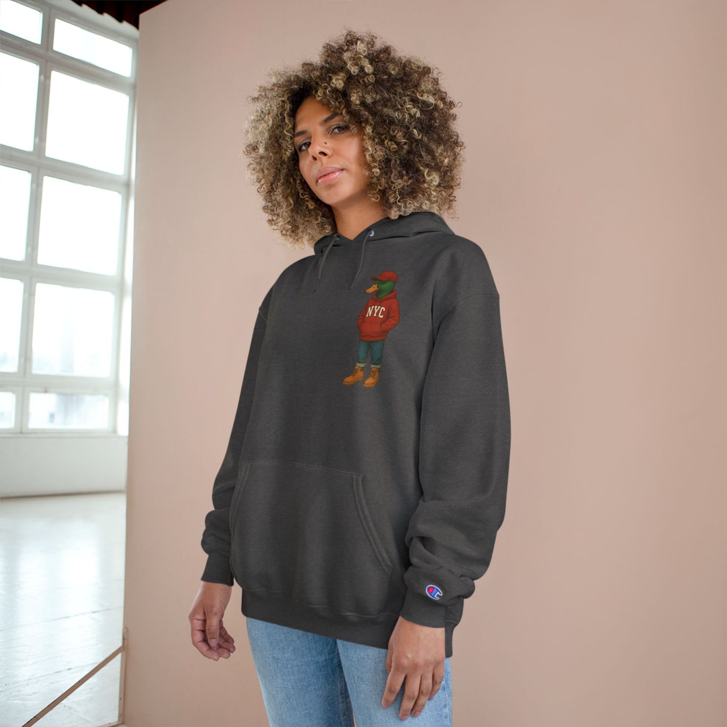 Female model wearing Charcoal NYC Duck Hoodie with anthropomorphic mallard duck chest graphic