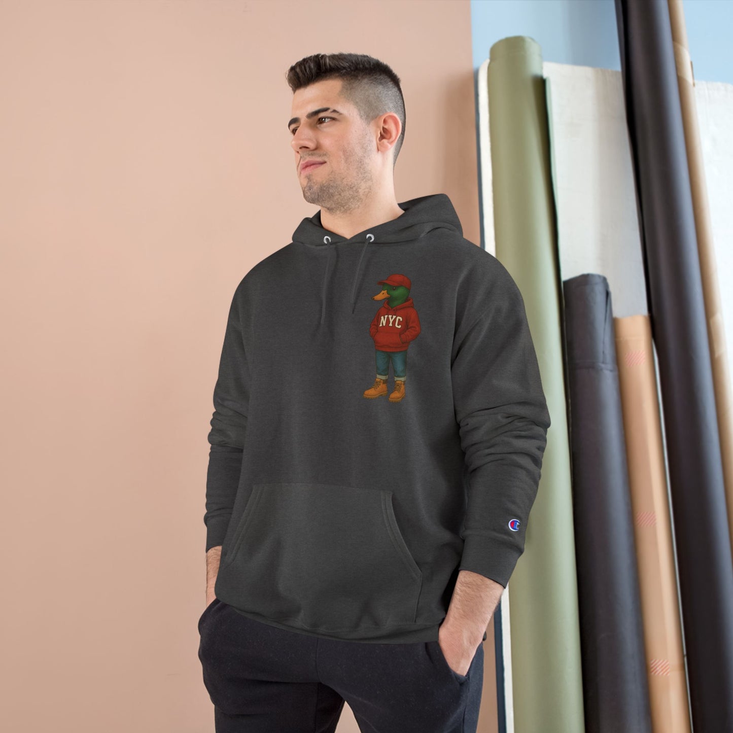 Male model wearing Charcoal NYC Duck Hoodie with anthropomorphic mallard duck chest graphic