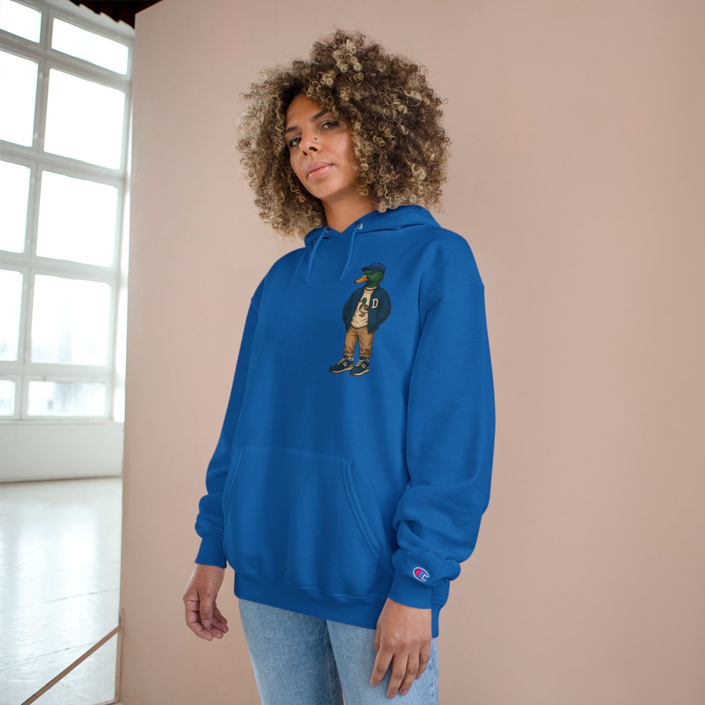 Female model wearing Royal Blue Varsity Duck Hoodie with anthropomorphic mallard duck chest graphic